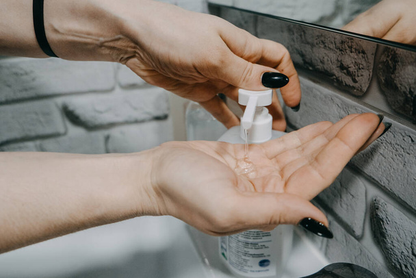 Les désinfectants gel pour les mains protègent contre le nouveau coronavirus. Femme utilisant une bouteille de gel de savon désinfectant antibactérien. Savon, désinfectant et eau chaude agissent contre Covid-19 et d'autres virus
. - Photo, image