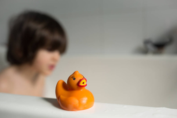 canard jouet au premier plan pendant que l'enfant se baigne dans la baignoire
 - Photo, image