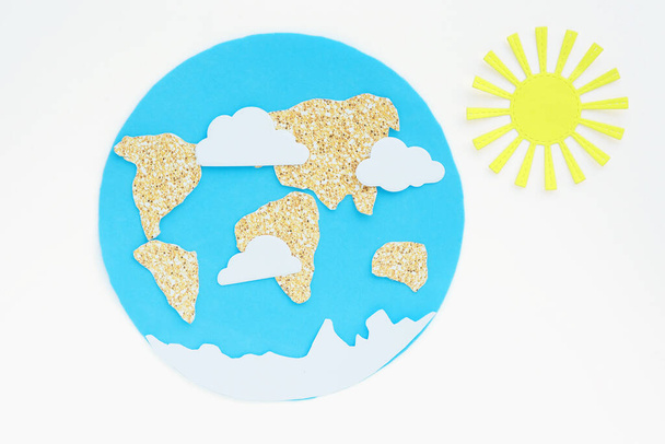 Zastosowanie papieru: planeta Ziemia, kontynenty, chmury i słońce. izolat na białym tle - Zdjęcie, obraz