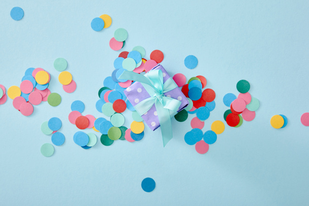 vue de dessus de confettis colorés près présent sur fond bleu
 - Photo, image