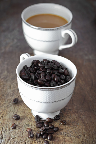 Taza de café y grano de café en una mesa de madera
 - Foto, imagen