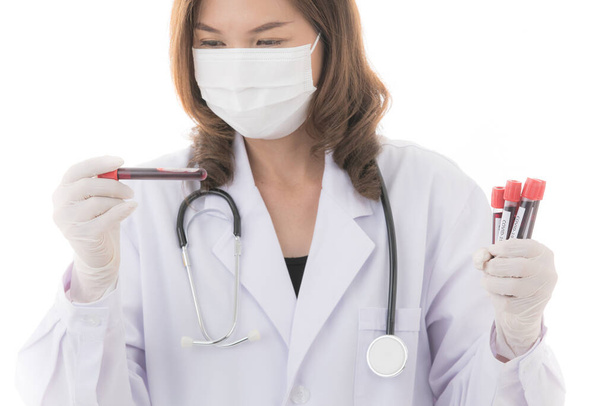 Жінка в лікарській сукні або лабораторному пальто з стетоскопом, що тримає набір тестових трубок Ковід-19 в руці. Ідея для медичних людей, які працюють і досліджують, як виграти коронавірусний спалах. - Фото, зображення