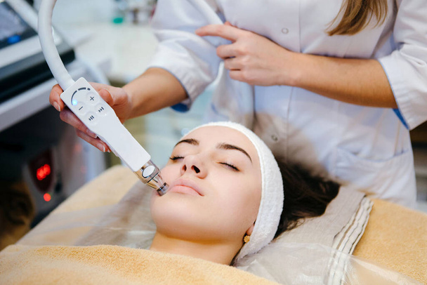 Kosmetologie-Klinik. Professionelle Kosmetikerin führt die Sauerstoffversorgung der Gesichtszellen durch. Schönheit Gesichtsbehandlung. Lifting-Effekt. - Foto, Bild