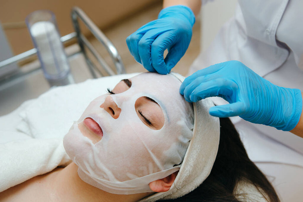 Face descascamento máscara, tratamento de beleza spa, cuidados com a pele. Mulher recebendo cuidados faciais por esteticista no salão de spa. - Foto, Imagem
