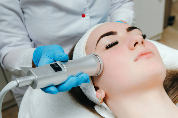Kosmetolog robiący metaterapię tlenową kobiecie w luksusowym salonie piękności. Pojęcie profesjonalnego leczenia twarzy. - Zdjęcie, obraz