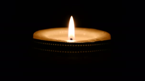 Opłakiwanie smutnej palącej się świecy na czarnym tle ku pamięci tych, którzy zmarli na skutek choroby COVID-19 wywołanej przez koronawirusa - Materiał filmowy, wideo