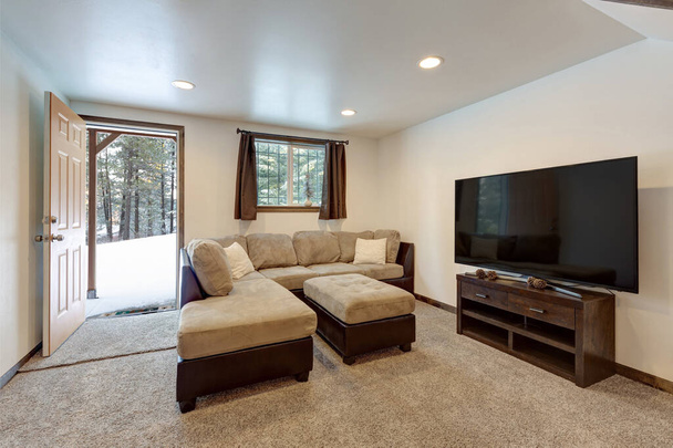 Interior de la sala de estar con sofá beige, toques naturales, cama litera de madera de construcción personalizada, techo alto, loft arriba
. - Foto, Imagen