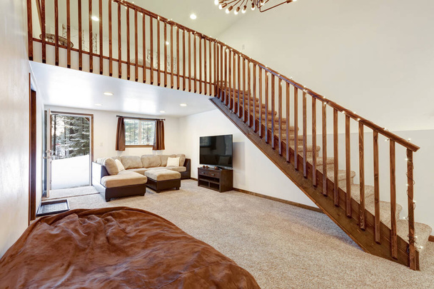 Woonkamer interieur met beige bank, natuurlijke accenten, op maat gemaakte houten stapelbed, hoog plafond, zolder boven. - Foto, afbeelding