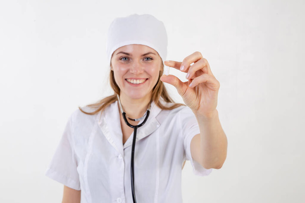 Een arts in een witte jas houdt een medicijn uit - Foto, afbeelding