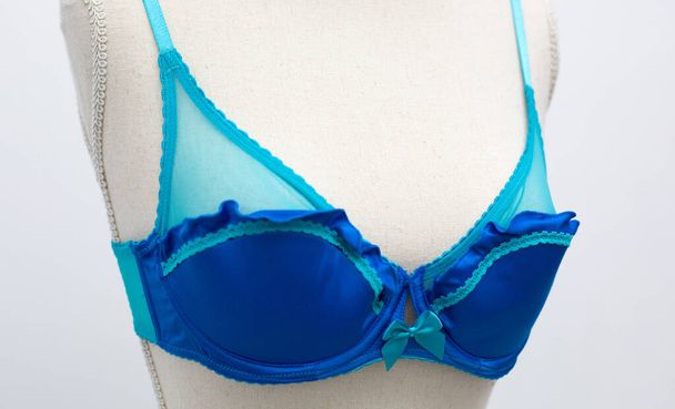 Beautiful lace blue lingerie bra small size with bow on dummy mannequin chest close up - Photo, Image