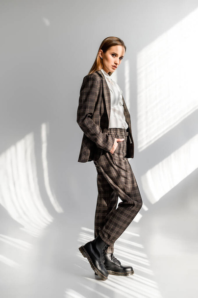 Attractive girl in a checkered suit on a white background. Catalog, clothing magazine - Φωτογραφία, εικόνα