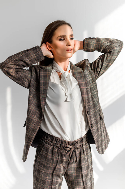 Attractive girl in a checkered suit on a white background. Catalog, clothing magazine - Fotografie, Obrázek