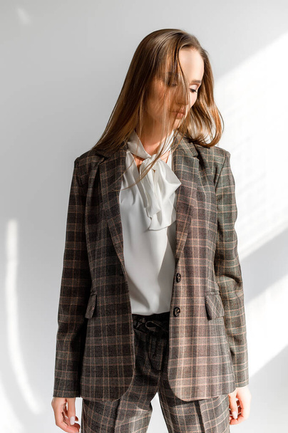 Attractive girl in a checkered suit on a white background. Catalog, clothing magazine - Фото, зображення