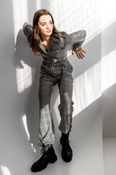 Attractive girl in checkered overalls on a white background. Catalog, clothing magazine - Φωτογραφία, εικόνα