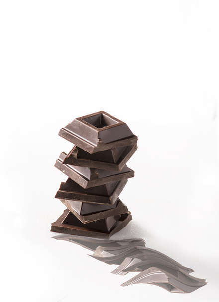 Quadrados de chocolate sobre fundo branco
 - Foto, Imagem