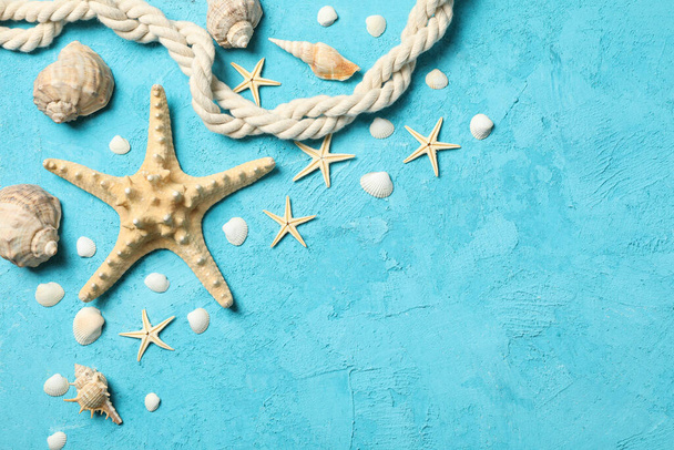 Морская звезда, веревка и ракушки на синем фоне, место для текста
 - Фото, изображение