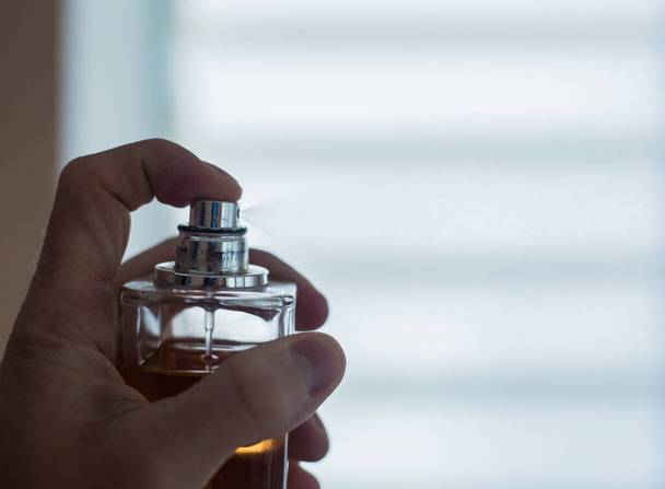 Pulvérisation de parfum à partir d'une bouteille en appuyant sur
 - Photo, image