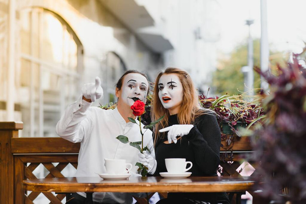 Mime in front of Paris cafe acting like drinking tea or coffee. - Foto, Imagen