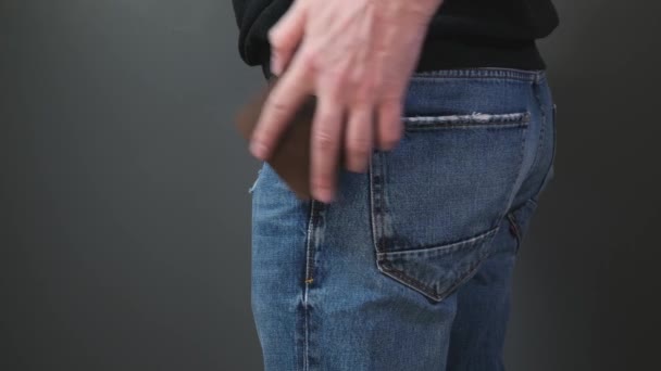Ręcznie włożyć portfel do kieszeni niebieskich dżinsów - Materiał filmowy, wideo
