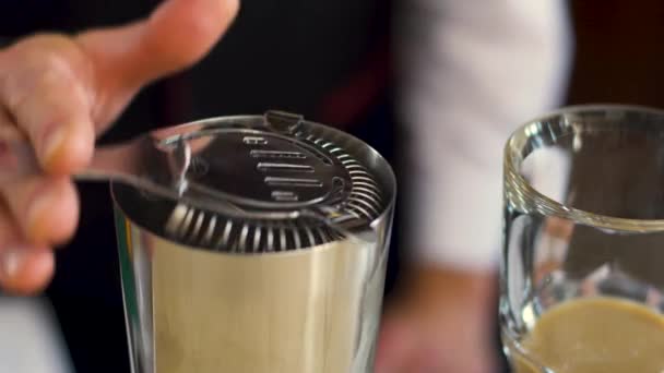 The bartender is preparing an alcoholic cocktail using a strainer. - Video