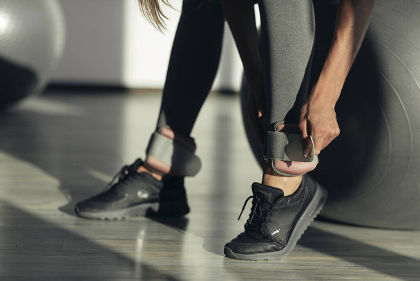 a női lábak közelsége sportsúlyokkal. nő edz az edzőteremben - Fotó, kép