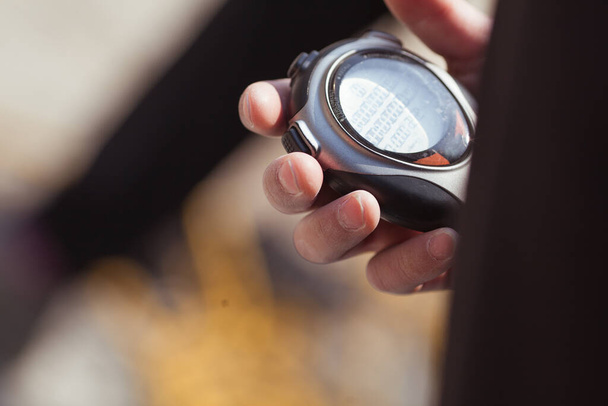 Hand holds gray stopwatch, outdoor - Foto, imagen