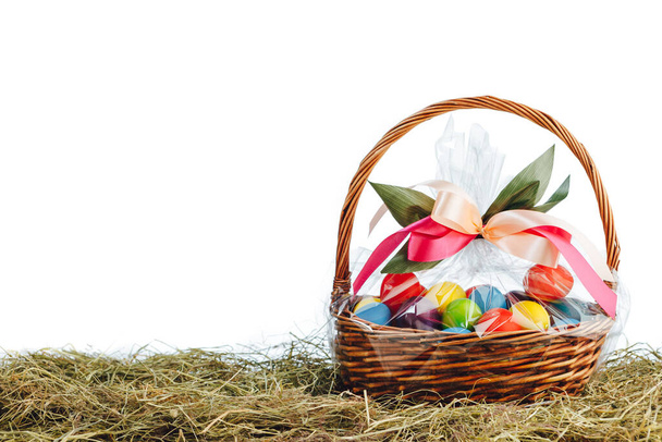 Easter gift basket with multicolor eggs, white background - Fotoğraf, Görsel