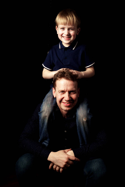 Portret ojca z synem na czarnym tle emocji - Zdjęcie, obraz