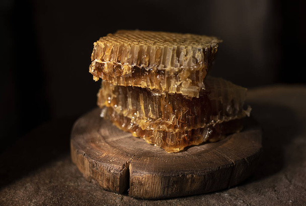 forest honey on a wooden stand, with beautiful light breaking through the curtains - Photo, Image