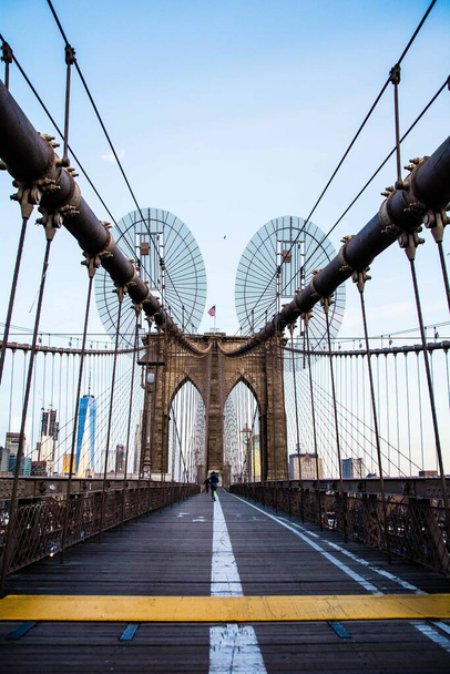 Вертикальный снимок Бруклинского моста в Нью-Йорке с ясным небом на заднем плане
 - Фото, изображение