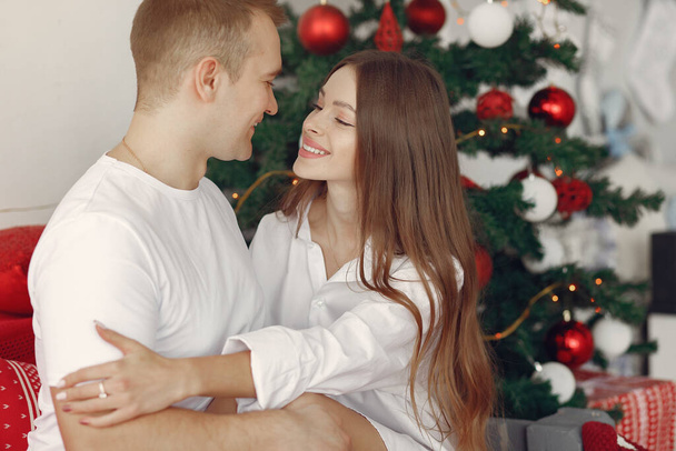 Elegante pareja en casa cerca del árbol de Navidad - Foto, imagen