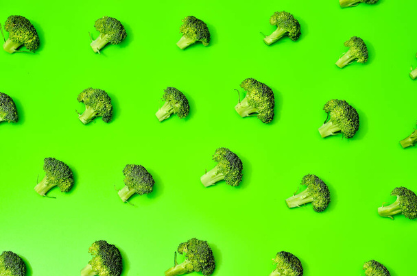 Pattern of many peaces of green broccoli on green background, healthy eating concept, space for text - 写真・画像
