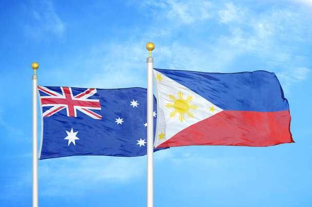 Australia i Filipiny dwie flagi na maszcie flagowym i niebieskie zachmurzone tło nieba - Zdjęcie, obraz
