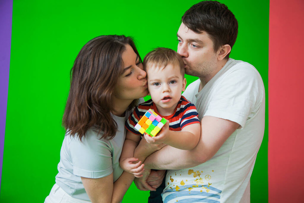Очаровательная молодая семья, мать, отец, держащий маленького ребенка сына
 - Фото, изображение