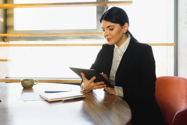 Portrait of an elegant businesswoman using tablet PC in a bright modern office - Φωτογραφία, εικόνα