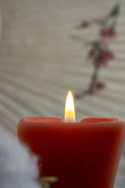 украшения, гигге и уют концепция - горящий белый аромат свечи и цветок хлопка на трикотажном одеяле
 - Фото, изображение
