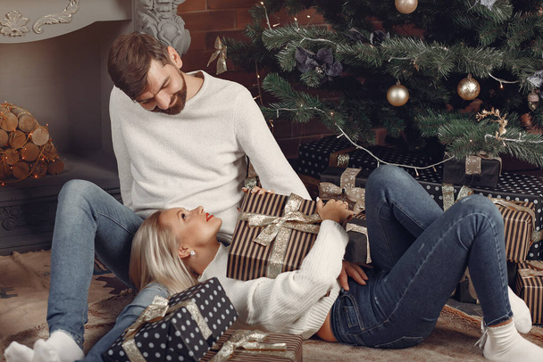 Beautiful couple sitting at home near christmas tree - Foto, immagini