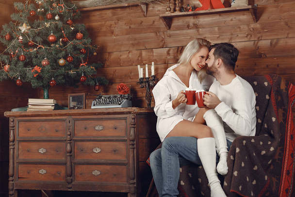 Beautiful couple sitting at home and drinking coffee - 写真・画像