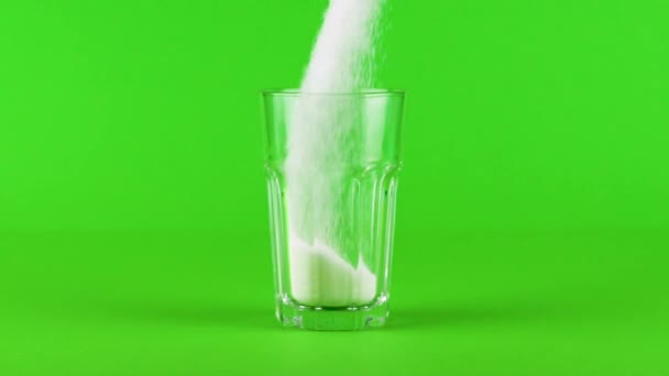 Öntsük cukor collins üveg vastag alsó zöld kontrasztos háttér lassított felvétel - Felvétel, videó