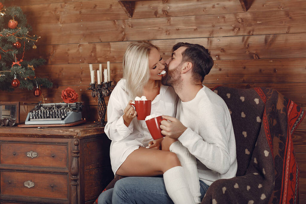 Beautiful couple sitting at home and drinking coffee - Zdjęcie, obraz