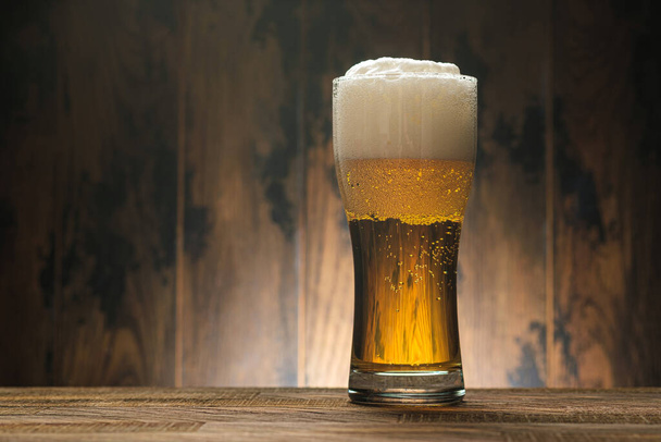 Piwo lekkie w szklance z pianką na drewnie z miejscem na ksero na pasku menu - Zdjęcie, obraz