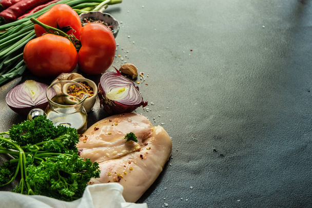 Keto-Ernährungskonzept mit rohem Hühnerfleisch mit frischem Gemüse und Kräutern auf Steinhintergrund mit Kopierfläche - Foto, Bild
