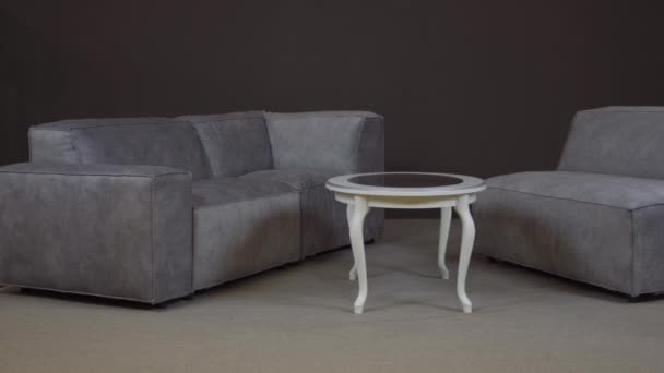 Minimalistický rohový gauč s bohatým sametovým čalouněním a moderním stolem - Záběry, video