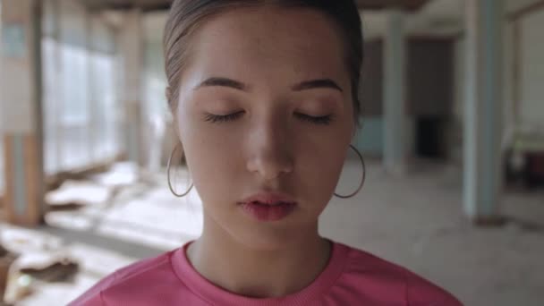 Porträt einer jungen Frau mit geschlossenen Augen. Verlassene Halle mit Panoramafenstern, Handkamera - Filmmaterial, Video