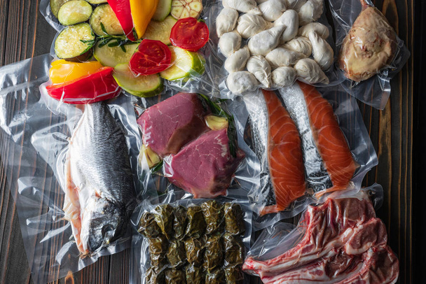 Los productos en el embalaje al vacío, en una tabla de madera. verduras, carne de pescado, dolma, kurza. Pandemia de cuarentena
 - Foto, Imagen