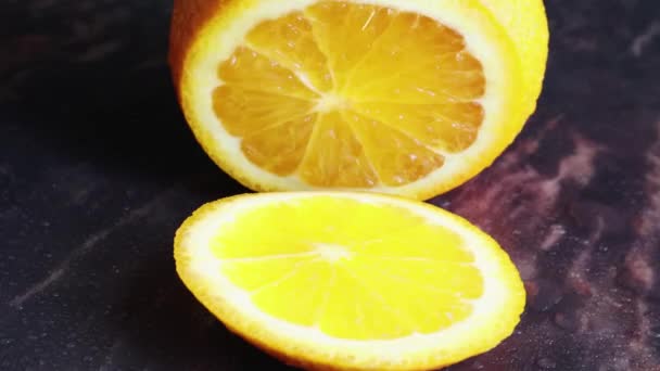 A female hand cuts with a knife round slices of juicy orange on the table. Housewife in the kitchen at home slicing fresh orange fruits on a cutting board. The concept of healthy eating, cooking - Footage, Video