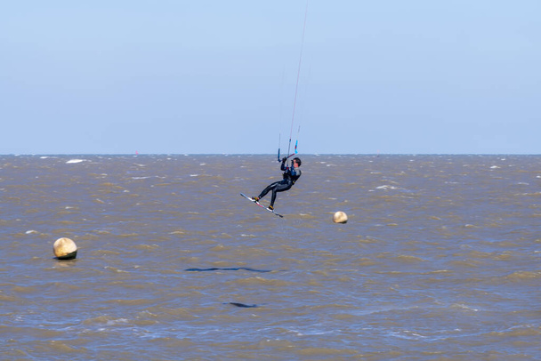 Um kite-surfista a trabalhar no vento e no surf do Canal da Mancha ao largo da costa de Kent, Whitstable
 - Foto, Imagem