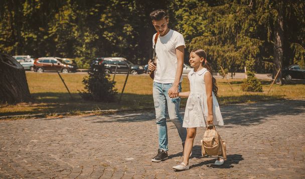Older Brother And Younger Sister Walking On City Street - Фото, зображення