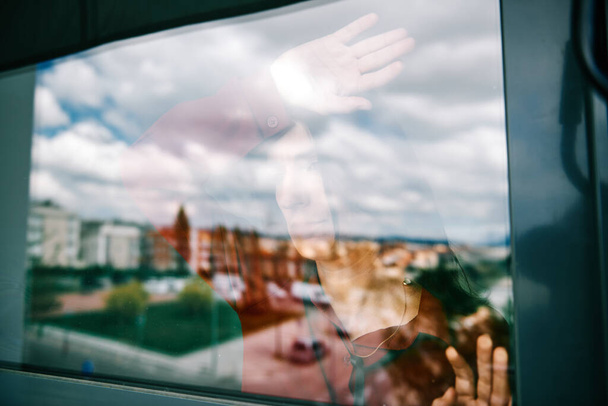 μια γυναίκα απομονωμένη κατά τη διάρκεια της επιδημίας covid-19 κοιτάζοντας μέσα από το παράθυρο - μείνετε στο σπίτι - Φωτογραφία, εικόνα