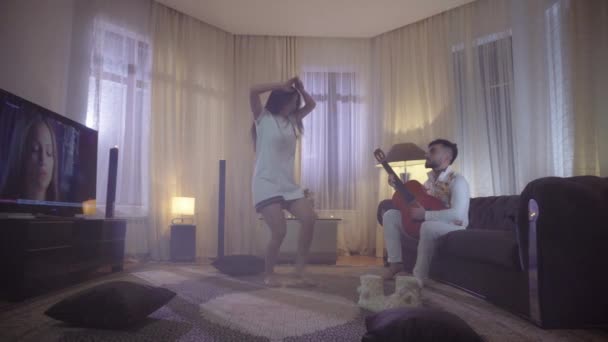 Guitarist Plays For Girl She Dances in night room - Materiał filmowy, wideo